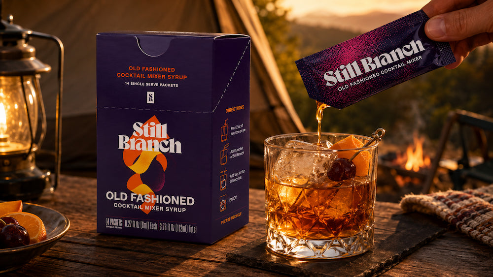 Still Branch Old Fashioned packet poured into a cup at a campsite for camping cocktails